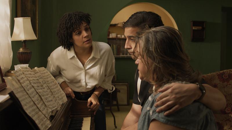 Abril and her two children in the green-walled apartment